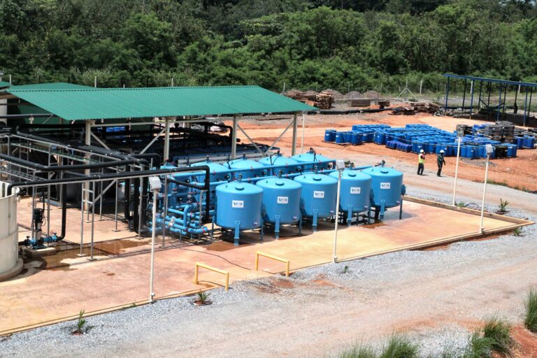 Completed water treatment plant with blue filter vessels under a green roof